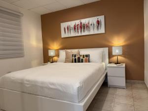 a bedroom with a large white bed and two lamps at Fontana Sunset - Spacious 3BR Family Home in Carolina