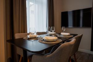 a dining room table with chairs and wine glasses at NEU im Zentrum stilvolle Premium-Suite mit Parkplatz in Gummersbach