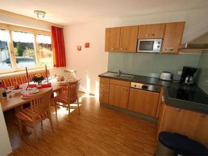 a kitchen with a table and a dining room at Apartment Künzel by Interhome in Schröcken