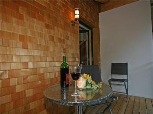 a table with a bottle of wine and a glass at Apartment Künzel by Interhome in Schröcken