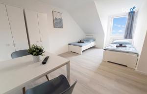a room with two beds and a table and chairs at BEGE APARTMENTS FlowLoft in Wegberg
