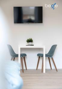 a white table with two chairs and a tv on a wall at BEGE APARTMENTS FlowLoft in Wegberg