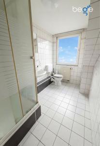 a bathroom with a shower and a toilet and a tub at BEGE APARTMENTS FlowLoft in Wegberg +13 photos