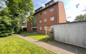 a brick building with a fence in front of it at BEGE APARTMENTS FlowLoft in Wegberg