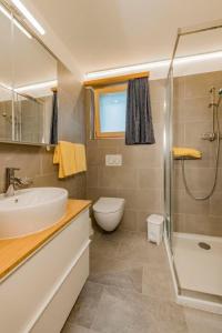 a bathroom with a sink and a toilet and a shower at Apartment Wohnung Muntegn by Interhome in Vicosoprano +3 photos