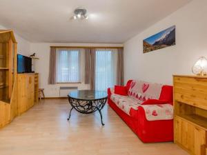 a living room with a red couch and a glass table at Apartment Wohnung Muntegn by Interhome in Vicosoprano