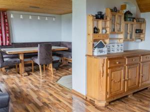 a kitchen and dining room with a wooden table and chairs at Apartment Haggen by Interhome in Oberegg