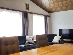 a living room with a couch and a television at Apartment Tgèsa Val by Interhome in Sedrun