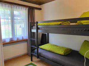 a bunk bed room with two bunk beds and a window at Apartment Tgèsa Val by Interhome in Sedrun