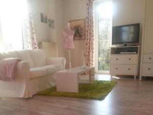 a living room with a white couch and a tv at Apartment Florö by Interhome in Putbus