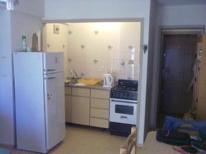 a kitchen with a white refrigerator and a stove at SAN CLEMENTE RIAZOr 6 in San Clemente del Tuyú