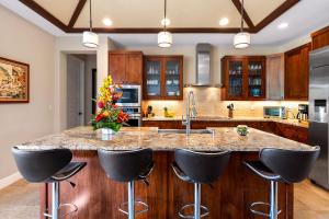 a kitchen with a large island with black bar stools at Kona Blue Vacations Holua Kai in Kailua-Kona