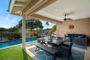 a patio with a table and chairs and a pool at Kona Blue Vacations Holua Kai in Kailua-Kona +43 photos