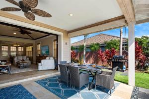 a patio with a table and chairs and a fireplace at Kona Blue Vacations Holua Kai in Kailua-Kona