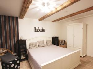 a bedroom with a white bed and a chair at Holiday Home Weideblick by Interhome in Geestland