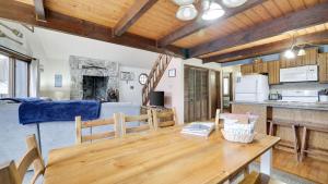 a kitchen and living room with a wooden table at Chalet All Day by AvantStay in Arrowhead Lake