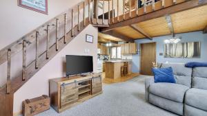 a living room with a couch and a television at Chalet All Day by AvantStay in Arrowhead Lake