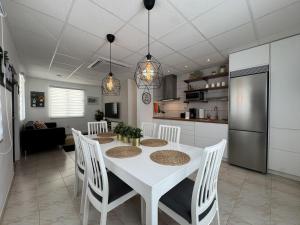 a kitchen and dining room with a white table and chairs at Fontana Sunset - Spacious 3BR Family Home in Carolina