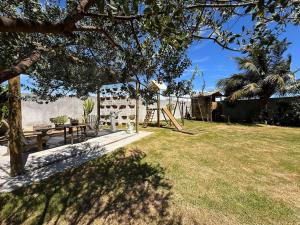 a yard with a picnic table and a playground at Casa Cações Beach Marataizes in Marataizes