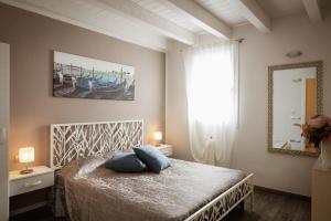 a bedroom with a bed with blue pillows and a mirror at Piccola Venezia Room in Chioggia