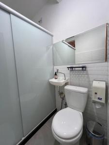 a white bathroom with a toilet and a sink at Flor do Mar - Hospedaria in Santa Cruz +17 photos