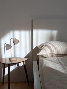 a table with a lamp on it next to a bed at Gardena Living in Ponte Gardena