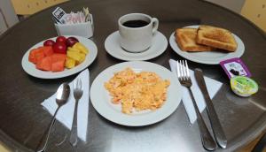 a table with plates of breakfast food and a cup of coffee at Hotel Oceanía Bogotá Museo in Bogotá