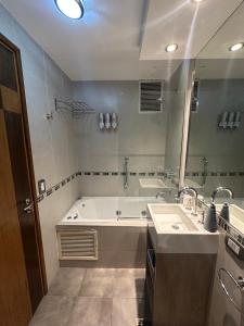 a bathroom with a tub and a sink and a mirror at Urban II - Cómodo monoambiente en pleno centro in San Juan