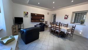 a living room with a couch and a table and chairs at La Casa del Torrente in Rieti