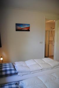 1 cama blanca en un dormitorio con una foto en la pared en Dunopark Villa, en Oostkapelle