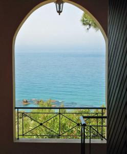 an arched window with a view of the ocean at Pool Apartments with panoramic Pelekas Beach view in Pelekas