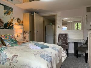 a bedroom with a bed and a kitchen with a refrigerator at Kwaterka in Brenna