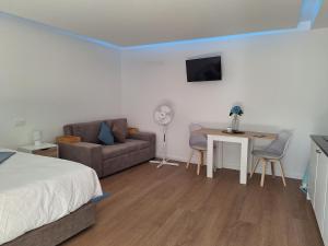 a bedroom with a bed and a couch and a table at AzoreanStar Accommodations in Ponta Delgada