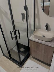 a bathroom with a glass shower with a sink at Stobrawa premium 2 in Kluczbork +8 photos