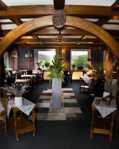 a restaurant with tables and chairs and a large room with plants at Weigands Hotel Peter in Reinhardshagen