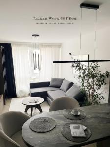 a living room with a couch and a table and chairs at Stobrawa premium 2 in Kluczbork