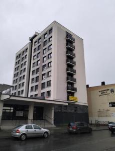 a large white building with cars parked in a parking lot at Stobrawa premium 2 in Kluczbork