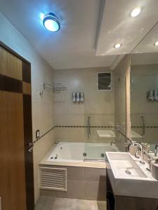 a bathroom with a bath tub and a sink at Urban III - Cómodo monoambiente en pleno centro in San Juan +3 photos