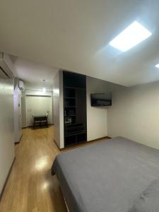 a bedroom with a bed and a flat screen tv at Urban III - Cómodo monoambiente en pleno centro in San Juan