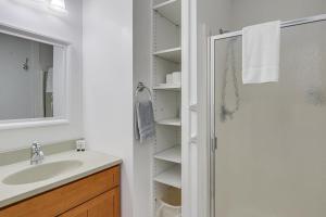 a white bathroom with a shower and a sink at Unbeatable Downtown Location! Bar Harbor Apt in Bar Harbor +16 photos