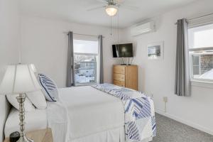 a white bedroom with a bed and a television at Unbeatable Downtown Location! Bar Harbor Apt in Bar Harbor