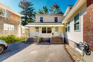 a white house with stairs leading to the front door at Unbeatable Downtown Location! Bar Harbor Apt in Bar Harbor