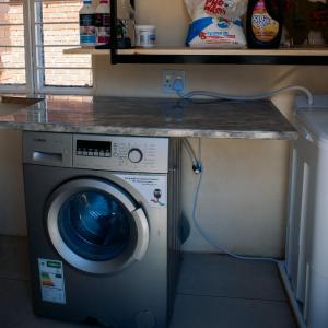 a washing machine in a kitchen with a counter at La Grande in Benoni