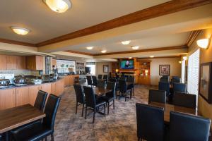 a restaurant with tables and chairs and a bar at Canalta Hotel Provost in Provost