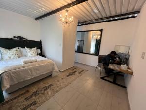 a man sitting at a table in a bedroom at La Grande in Benoni