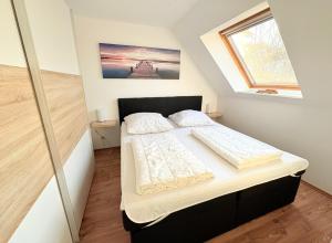 a small bedroom with a bed in a attic at Fewo Lebensart - in bester Lage, mit TG und Balkon in Baabe