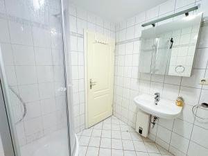a white bathroom with a sink and a shower at Fewo Lebensart - in bester Lage, mit TG und Balkon in Baabe +12 photos