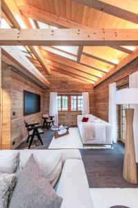 a living room with a white couch and a tv at Chalet Chalet Andra by Interhome in Grindelwald
