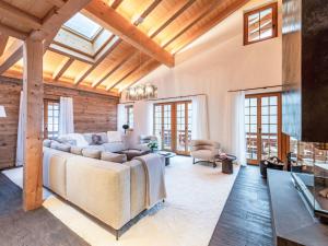 a living room with a couch and a tv at Chalet Chalet Andra by Interhome in Grindelwald