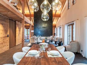 a dining room with a wooden table and white chairs at Chalet Chalet Andra by Interhome in Grindelwald